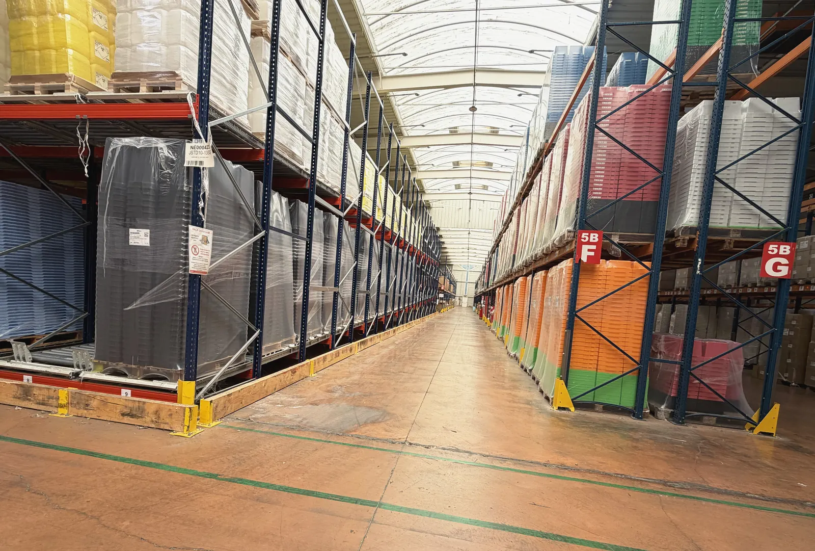 Allée de racks de stockage de produits finis dans l'entrepôt Plazur Industries.
