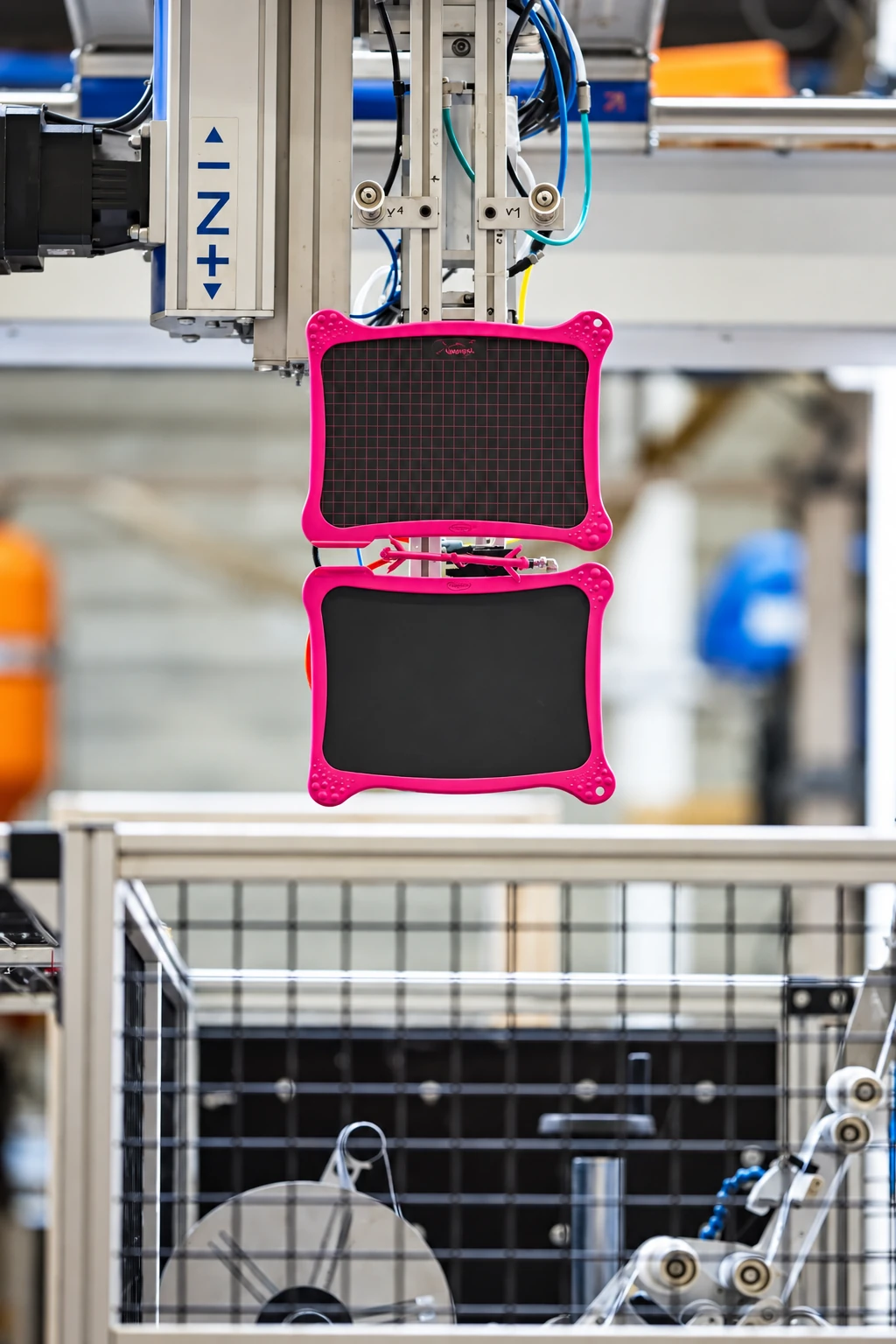 Pièces plastiques bi-matière tenues par un préhenseur en sortie de presse, Plazur Industries.
